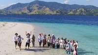 Foto bersama teman-teman dengan latar belakang gradasi warna laut dan bukit padang savana