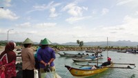 ibu-ibu menunggu nelayan menurunkan ikan