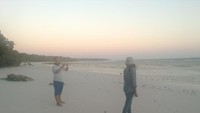Seorang pengunjung yang sedang asyik berfoto di pantai bara