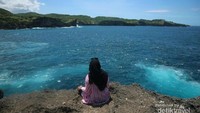 Menikmati laut yang jernih dengan bukit di depannya