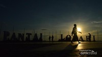 Seseorang tengah melintas di taman Pantai Losari Makassar