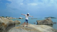 Hamparan batu granit dengan latar belakang langit biru menjadi daya tarik Pantai Penyusuk