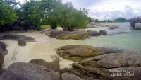 Pemandangan pantai yang dihiasi batuan granit yang banyak