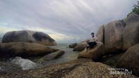 Menikmati sore di pantai tanjung tinggi sambil duduk diatas batuan yang tinggi