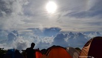 Para pendaki berlatar awan