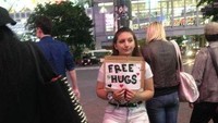 Pelukan gratis diberikan oleh gadis bule cantik ini bagi siapapun yang menginginkannya. Dia berdiri sepanjang malam di perempatan tersibuk, depan Stasiun Shibuya, Tokyo, Jepang.
