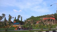 Tugu ini terletak di taman hijau dan berbunga yang indah