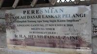 Papan nama yang terdapat di depan bangunan sekolah.
