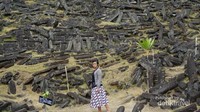 Berfoto dengan latar belakang bebatuan yang berserakan.