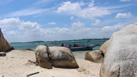 Perahu bersandar di pantai yang berpasir putih.