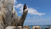 Pemandu kami berfoto di atas batu yang unik