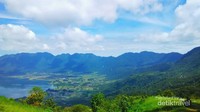 Danau dan langit yang biru berpadu harmonis dengan bukit hijau disekelilingnya