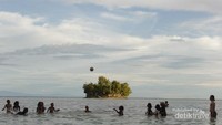 Anak-anak setempat bermain bola di laut Raja Tiga Adoki.