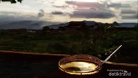 Secangkir kopi arjuno dengan latar belakang gunung