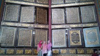Pengunjung berfoto  dengan Al Quran raksasa