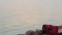 Liburan tak lupa bawa kamera dan kacamata hitam