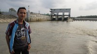 Berfoto di depan bendungan