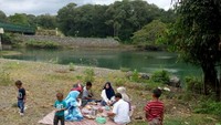 Makan bersama keluarga di pinggir sungai
