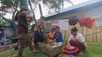 Para perempuan menumbuk kopi menggunakan lesung.