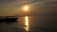 Duduk menikmati pantai dan menyaksikan matahari pulang ke peraduannya .