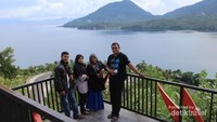 Wisatawan berfoto dengan view Laut