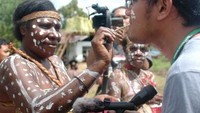 Mama mencoretkan cat putih sebagai ucapan selamat datang bagi tamu