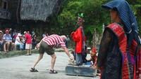 Beberapa wiswatawan yang menyaksikan Tari Tor-tor dan Sigale-gale akan memasukkan uang di wadah yang terdapat di bawah Sigale-gale (Calvin Damas Emil/ACI)