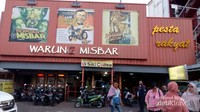 Bagian depan warung misbar dengan poster film bernuansa jadul.