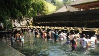 Pengunjung melukat di kolam pemandian