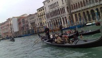 Gondola yang membawa turis keliling melalui Grand Canal