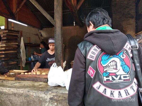 Salah satu pengunjung Desa Cileumbu membeli dan berkunjung ke pengolahan tahu Sumedang.