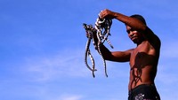 Warga setempat yang sedang mengang ular-ular penghuni Pulau Ular (beach-indonesia.blogspot.com)