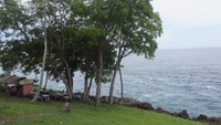 Hamparan laut biru nan luas terlihat dari atas bukit