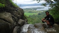 melihat ke air terjun dengan latar danu toba