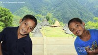 Anak Wae Rebo dengan latar belakang kampung