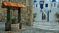 Spot Foto Area Santorini dengan sumur tua khasnya dan bangunan khas putih birunya.