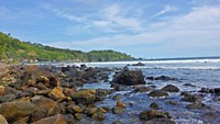 Bagian ujung pantai dengan perbukitan yang memanjang dengan kabut tipis