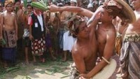 Dua pemuda saling menyerang dengan beberapa helai daun pandang yang di gabungkan menjadi satu genggaman.