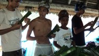 Peserta perang pandan sedang memilih pandan yang akan digunakan. Tidak hanya orang dewasa, anak di bawah umur juga ada yang mengikuti perang ini.