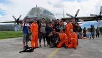 Tim Dream Destination Papua berfoto di bandara wamena berlatar pesawat Hercules