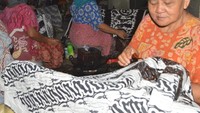 Perajin batik sedang melukis batik