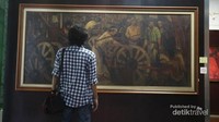 Di hadapan lukisan karya Sapto Hudoyo, seorang pelukis beraliran realisme.