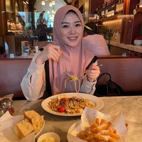 Ayana Moon menggunakan hijab bergo warna pink saat asyik menyantap makanan di sebuah restoran. Hijab andalan tersebut merupakan kolaborasinya bersama online shop hijab.  Foto: Dok. Instagram @xolovelyayana.