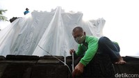 Petugas mengikat tali agar plastik tidak lepas.