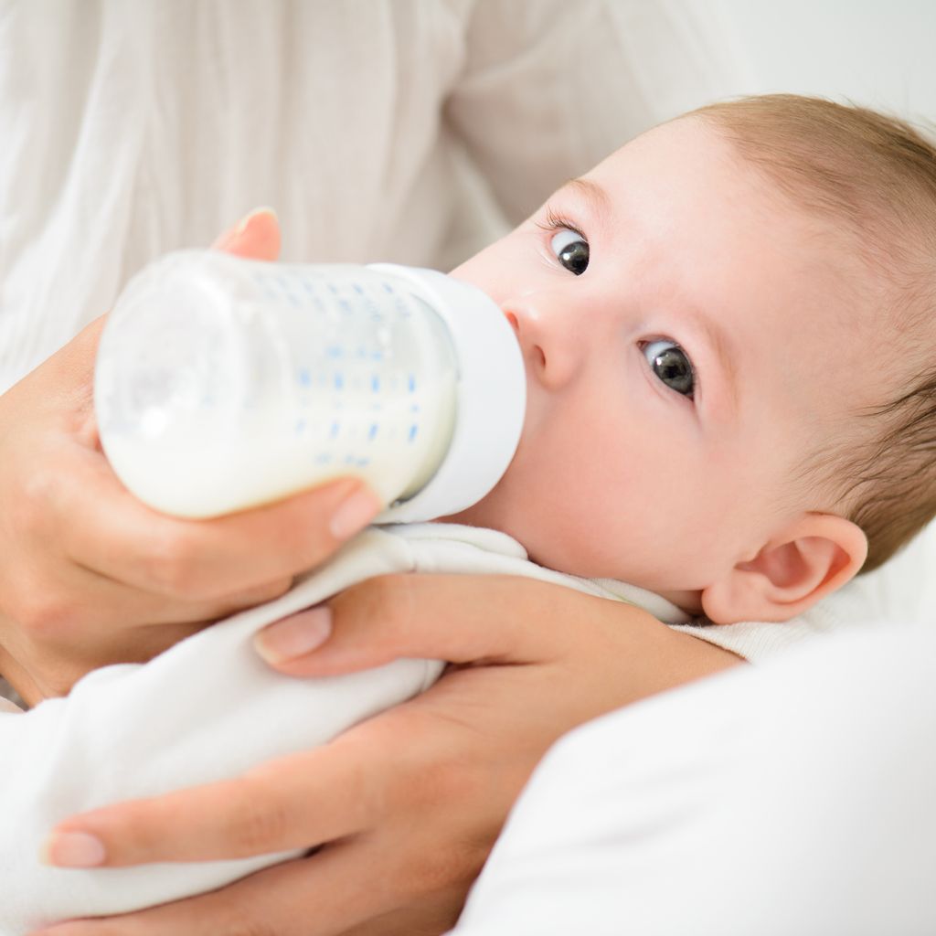 A detail shot of cute baby drinking milk from bootle