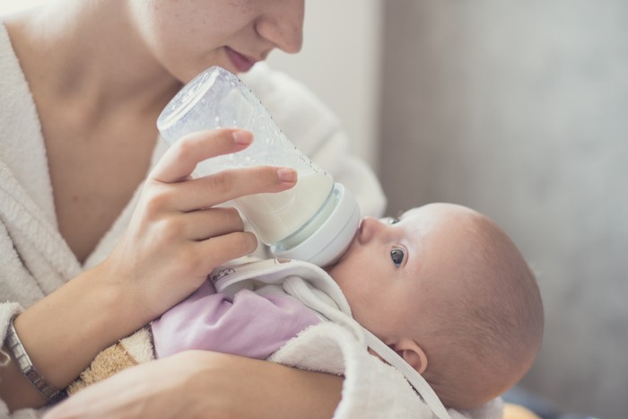 Copy-spaced image of a mother feeding her little baby from the milkbottle