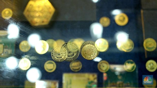Petugas menunjukkan koin emas Dirham di Gerai Butik Emas Antam, Jakarta, Kamis (4/2/2021). Bank Indonesia (BI) mengajak masyarakat dan berbagai pihak untuk menjaga kedaulatan Rupiah sebagai mata uang NKRI.    (CNBC Indonesia/ Tri Susislo)