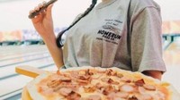 Saat main bowling, Lindsey memesan pizza dari kafenya. Ia terlihat berpose keren dengan pizza tersebut. Foto: Instagram @lindseyls