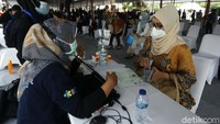 Seorang peserta menunjukan data diri sebelum mengikuti program vaksinasi massal.