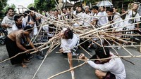 Kemudian mereka berkumpul di sumber mata air dengan membawa tongkat sepanjang 2-5 meter. Tongkat tersebut akan digunakan untuk membentuk piramida. Agar mempermudah, peserta bisa naik ke puncaknya untuk memberikan komando. Tujuannya yaitu untuk menabrakkan piramida tongkat dari kelompok lain. Putu Sayoga/Getty Images  